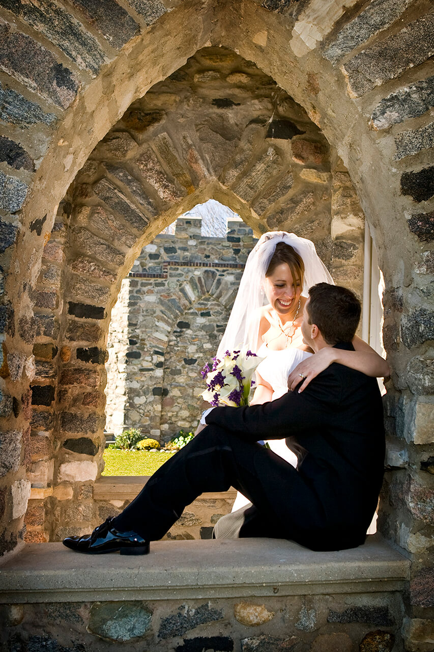 Bride and groom in window archway