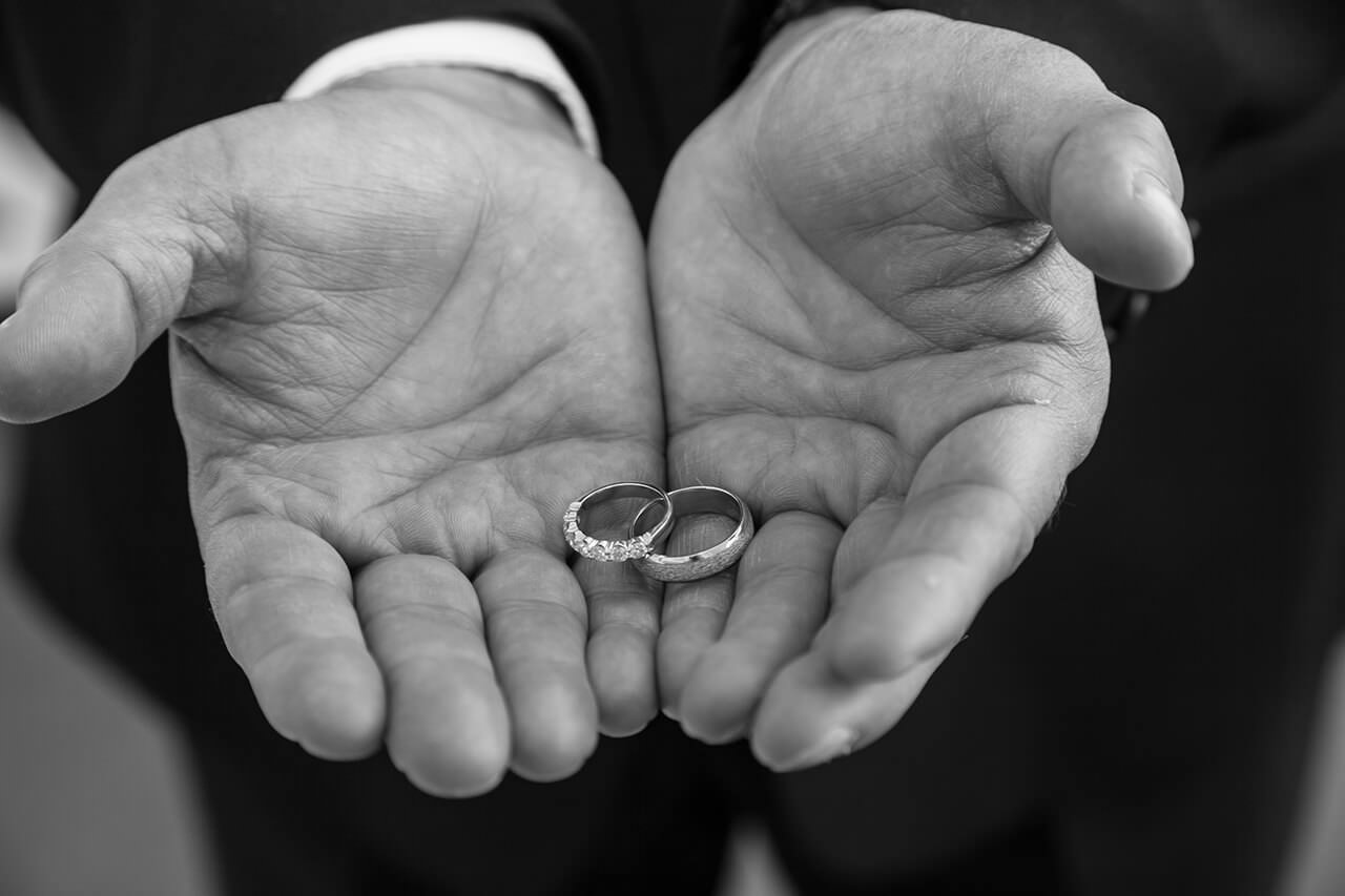 Black and white photo of wedding rings any pair of hands