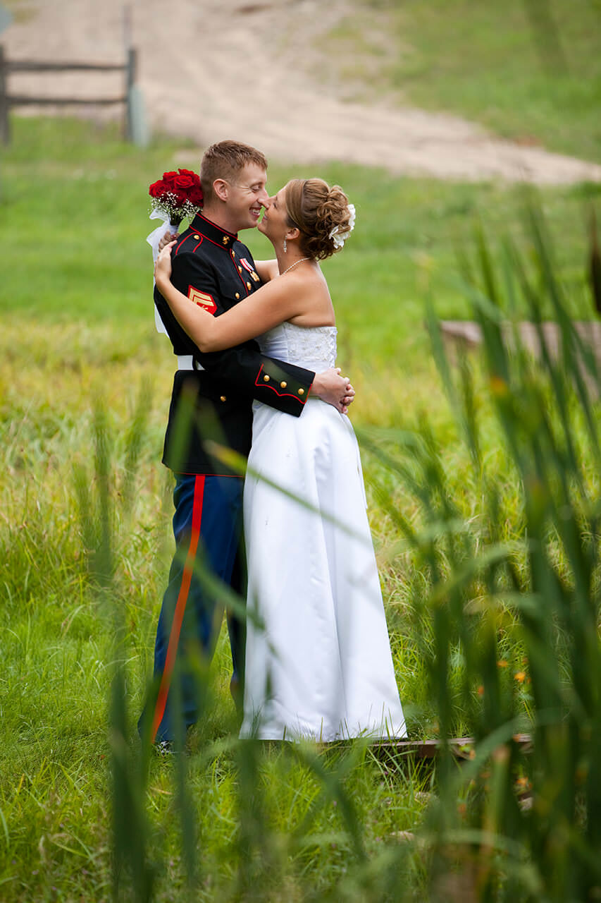 Military groom embracing his bride outdoors