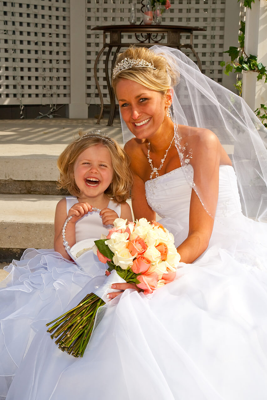 Bride laughing with her flower girl