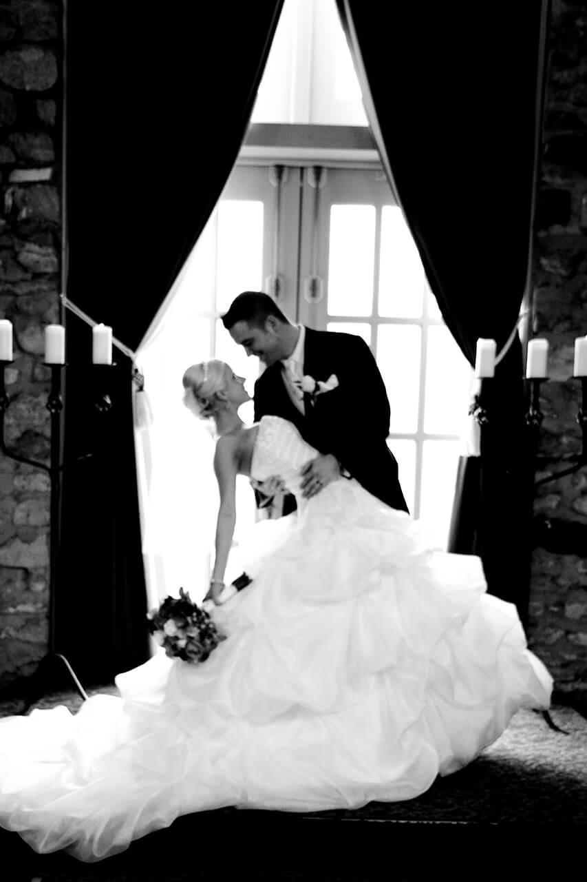 Black and white photo of groom dipping his bride