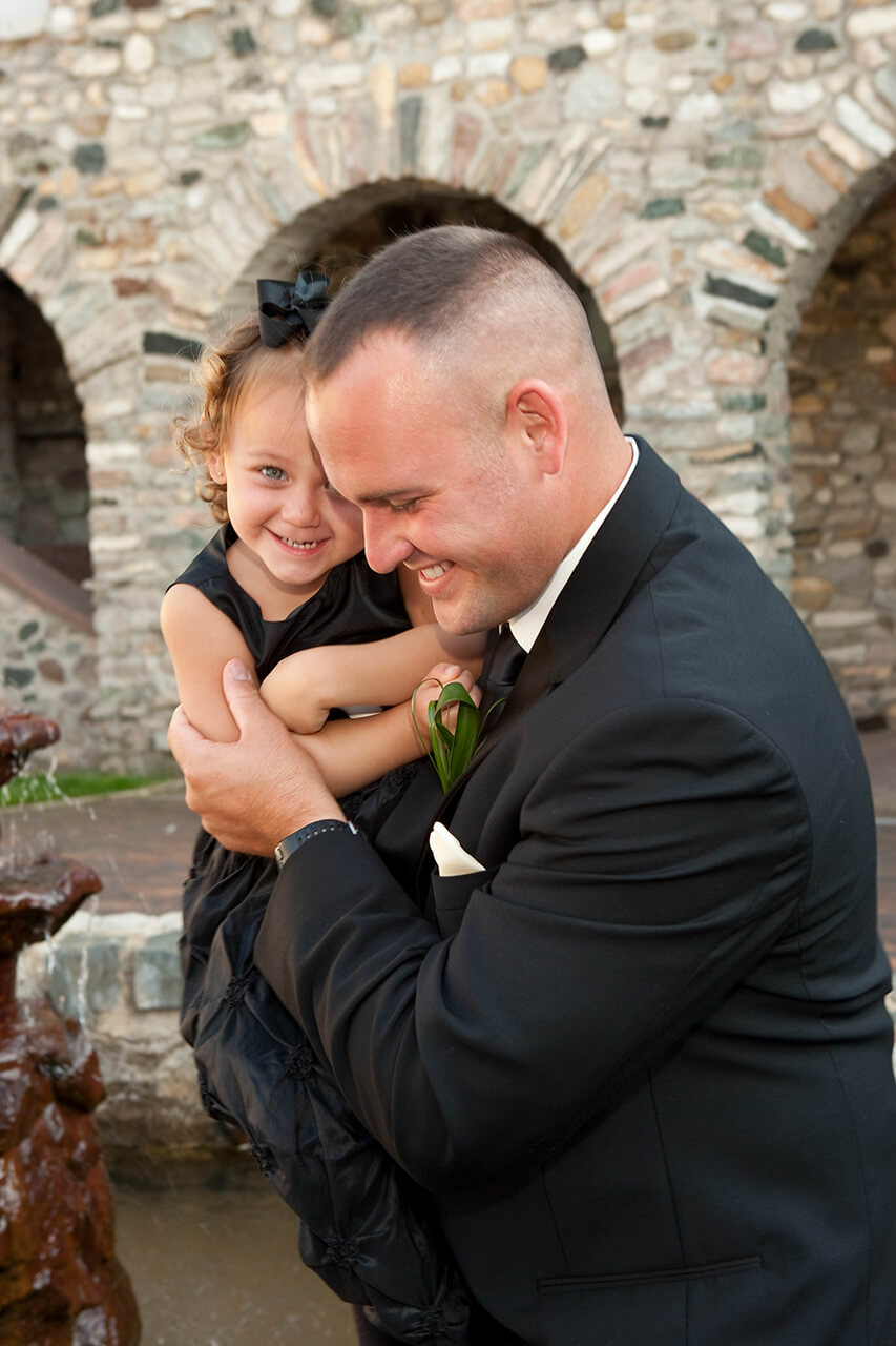 Groom holding a young child at wedding